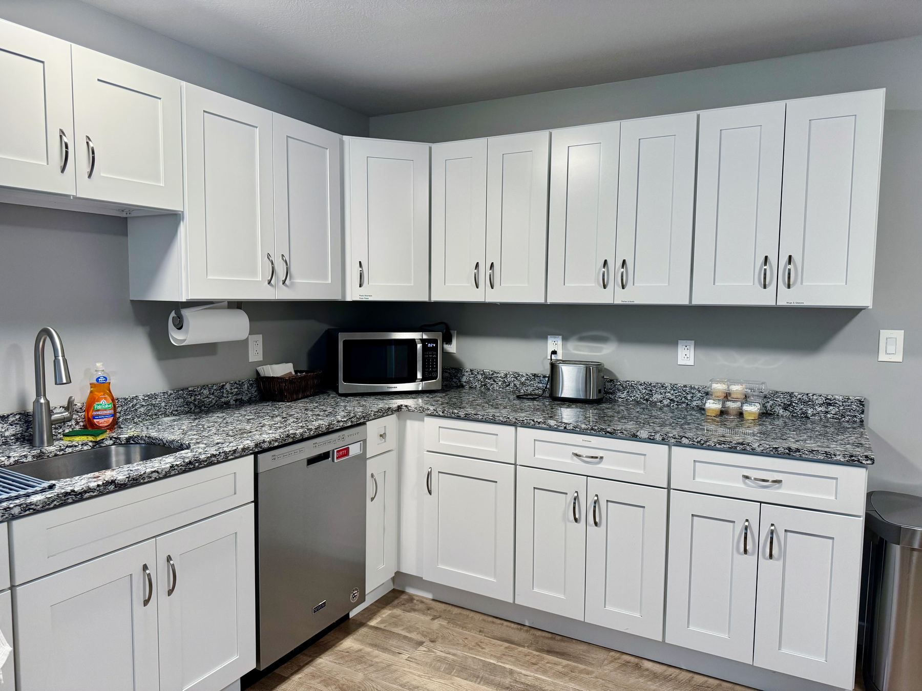Kitchen with white cabinets, granite counters, and a stainless sink