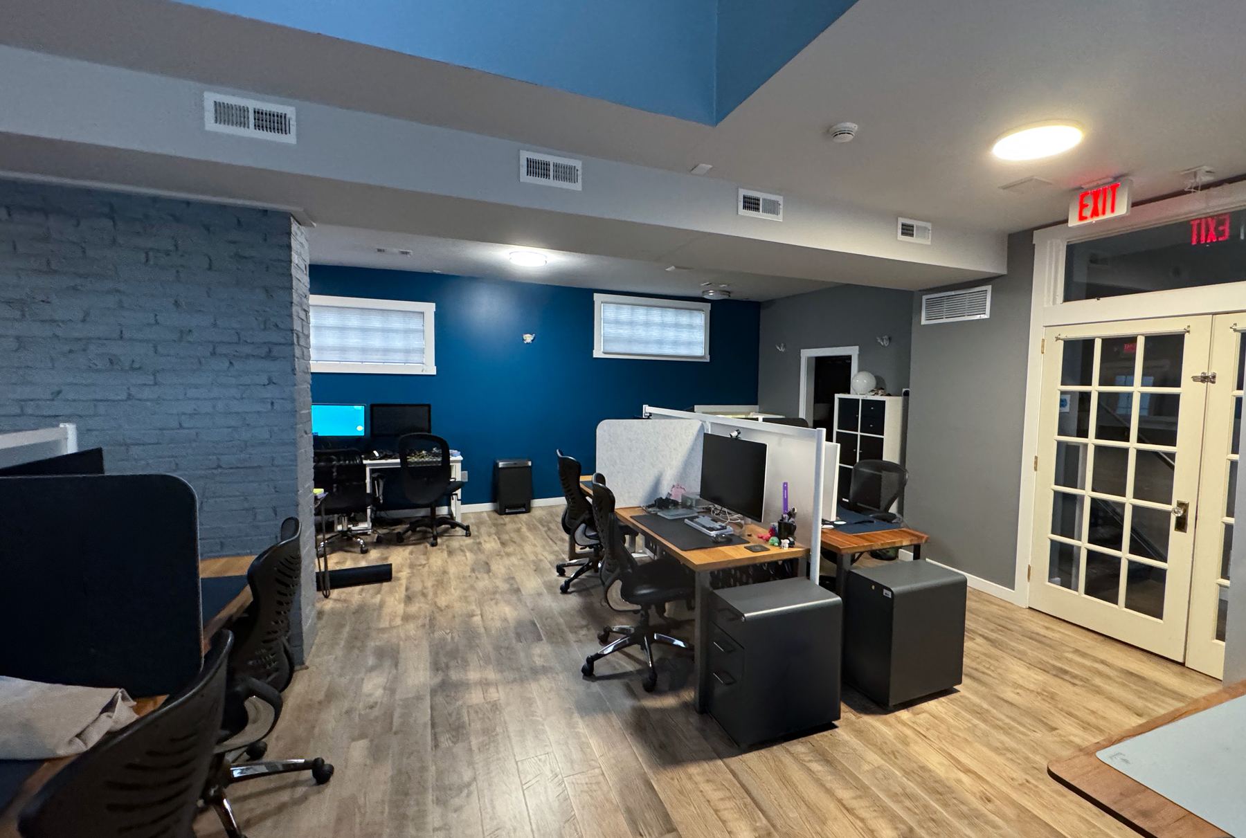 Interior of the PerryWorks building with wood desks and a slate wall